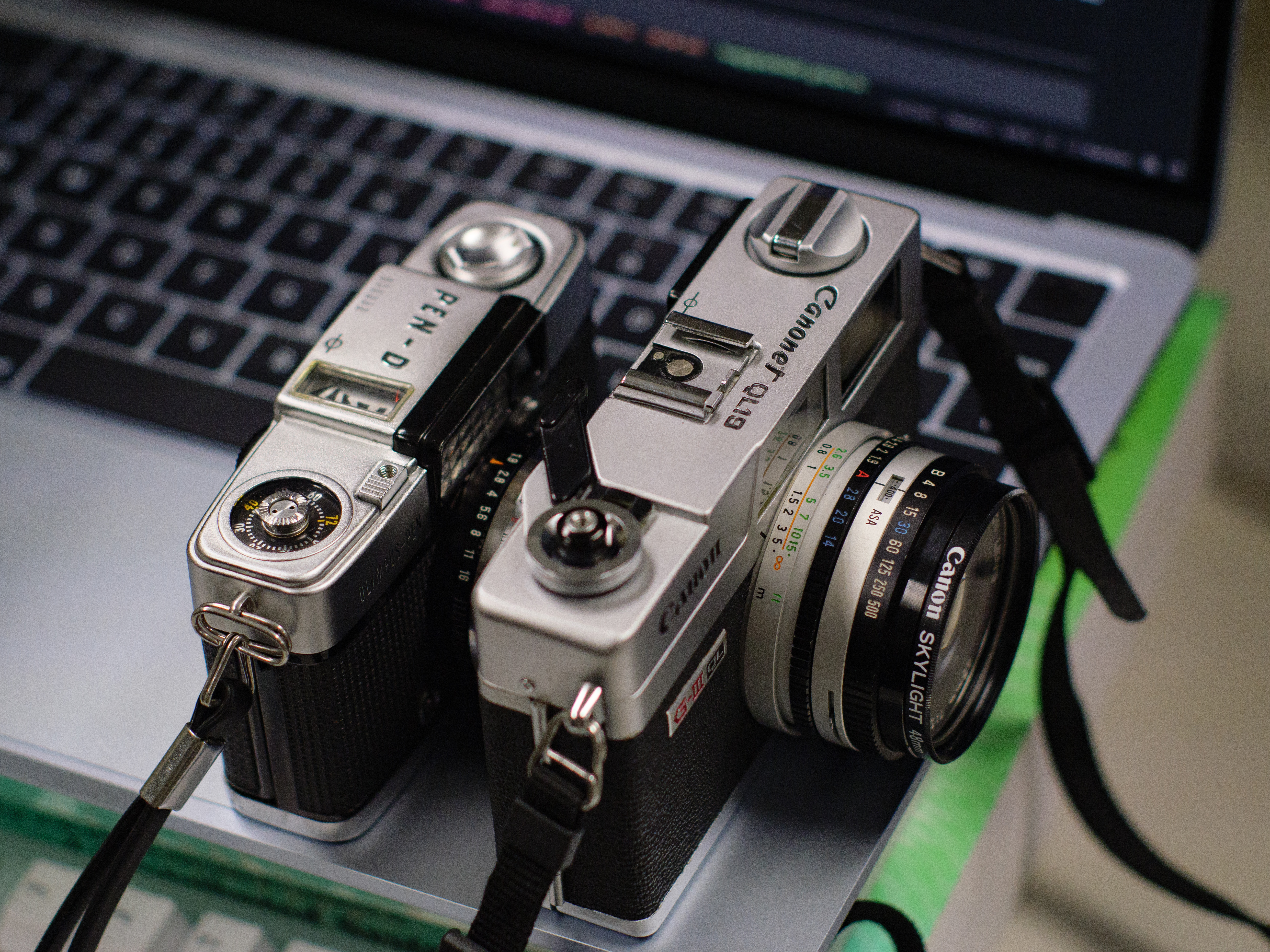 My two film cameras against the edge of a MacBook Air M4